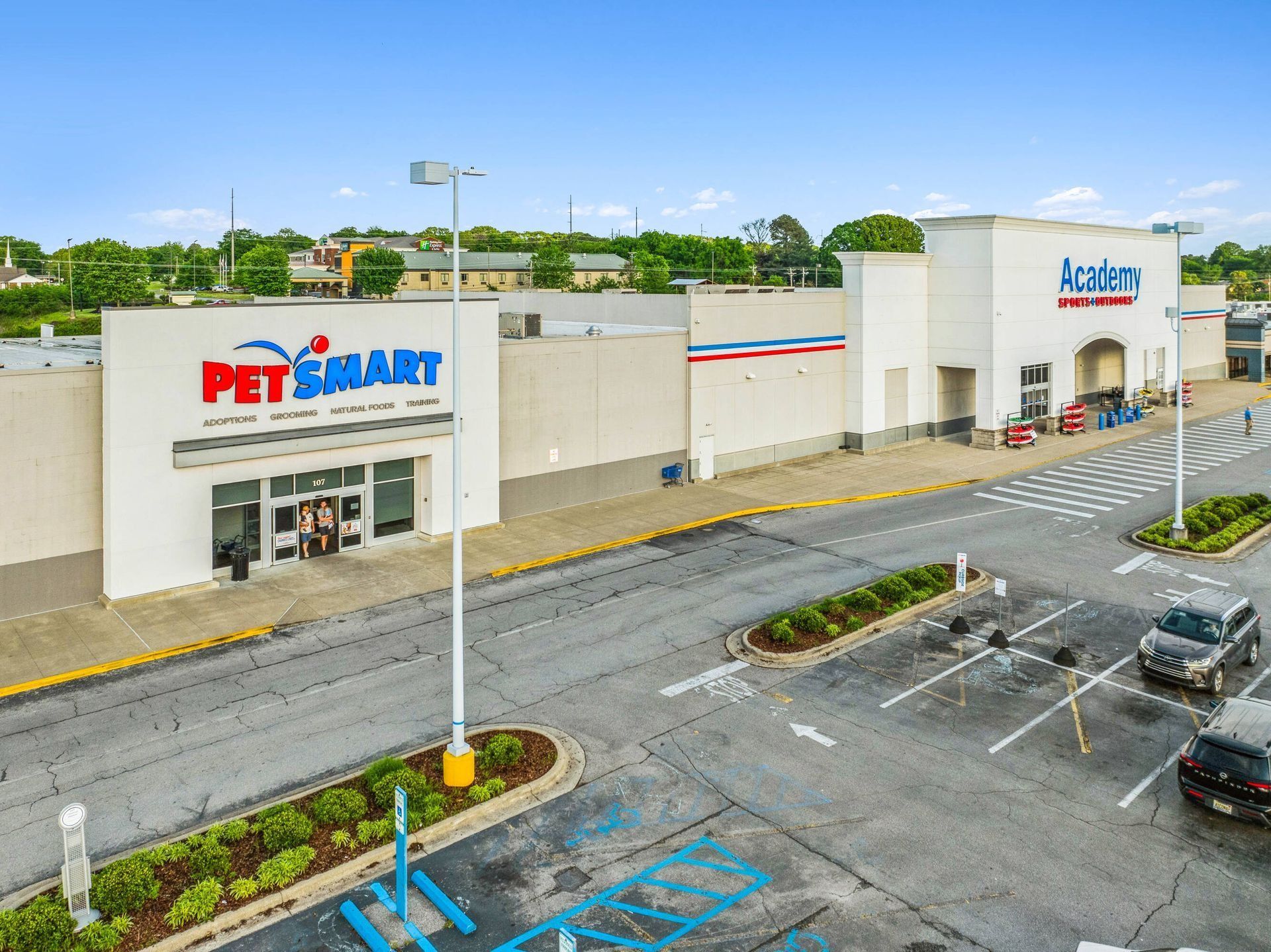 PetSmart storefront and neighboring retail building beside an empty parking lot on a cloudy day