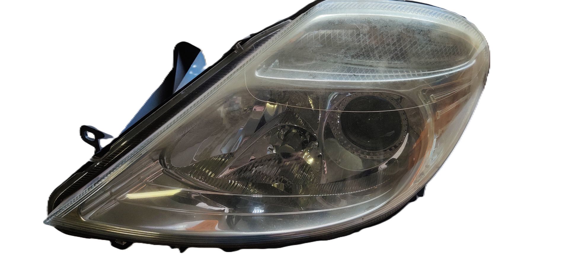 Een heldere, druppelvormige autokoplampunit met een centrale projectorlens en een richtingaanwijzerreflector.