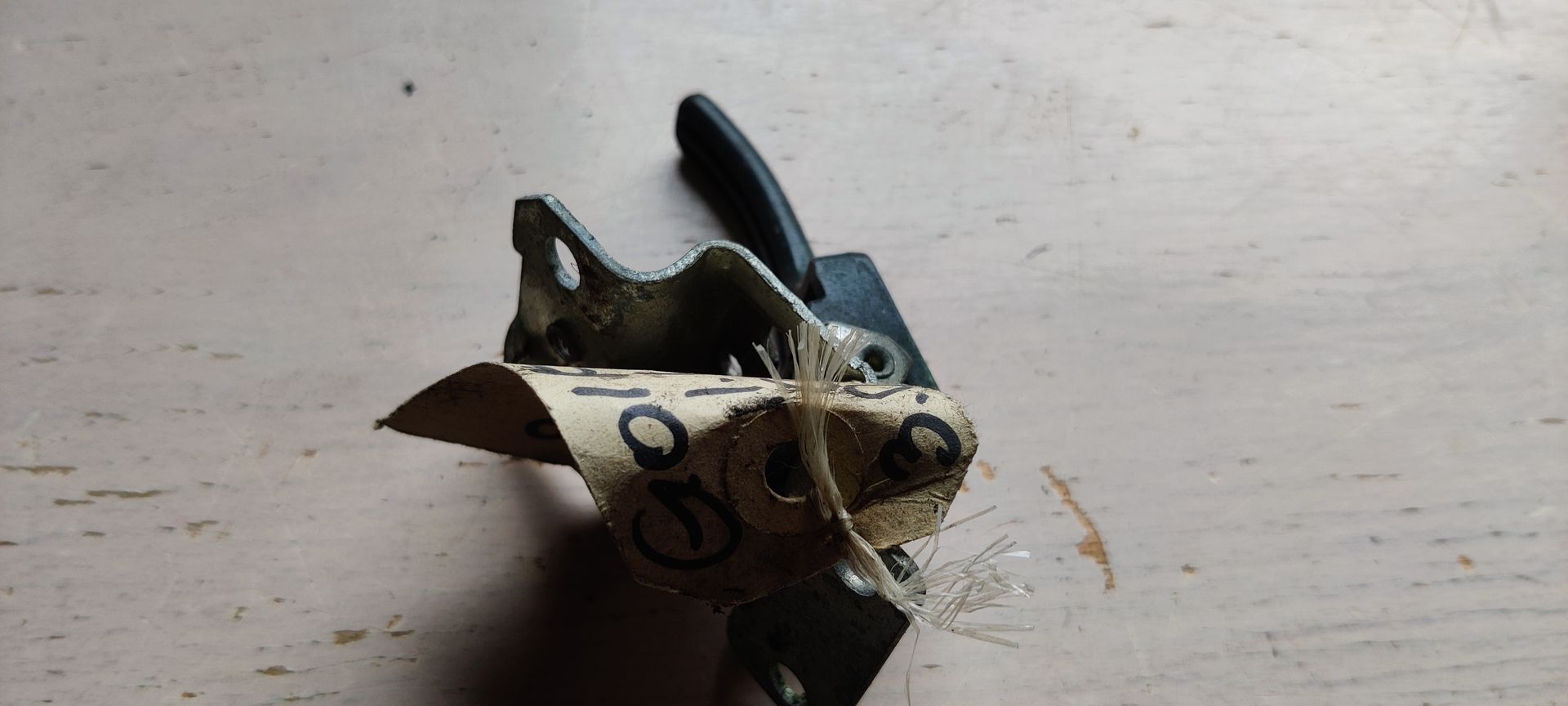 Een zwart metalen deurslot met montagebeugel, afgebeeld tegen een effen witte achtergrond.