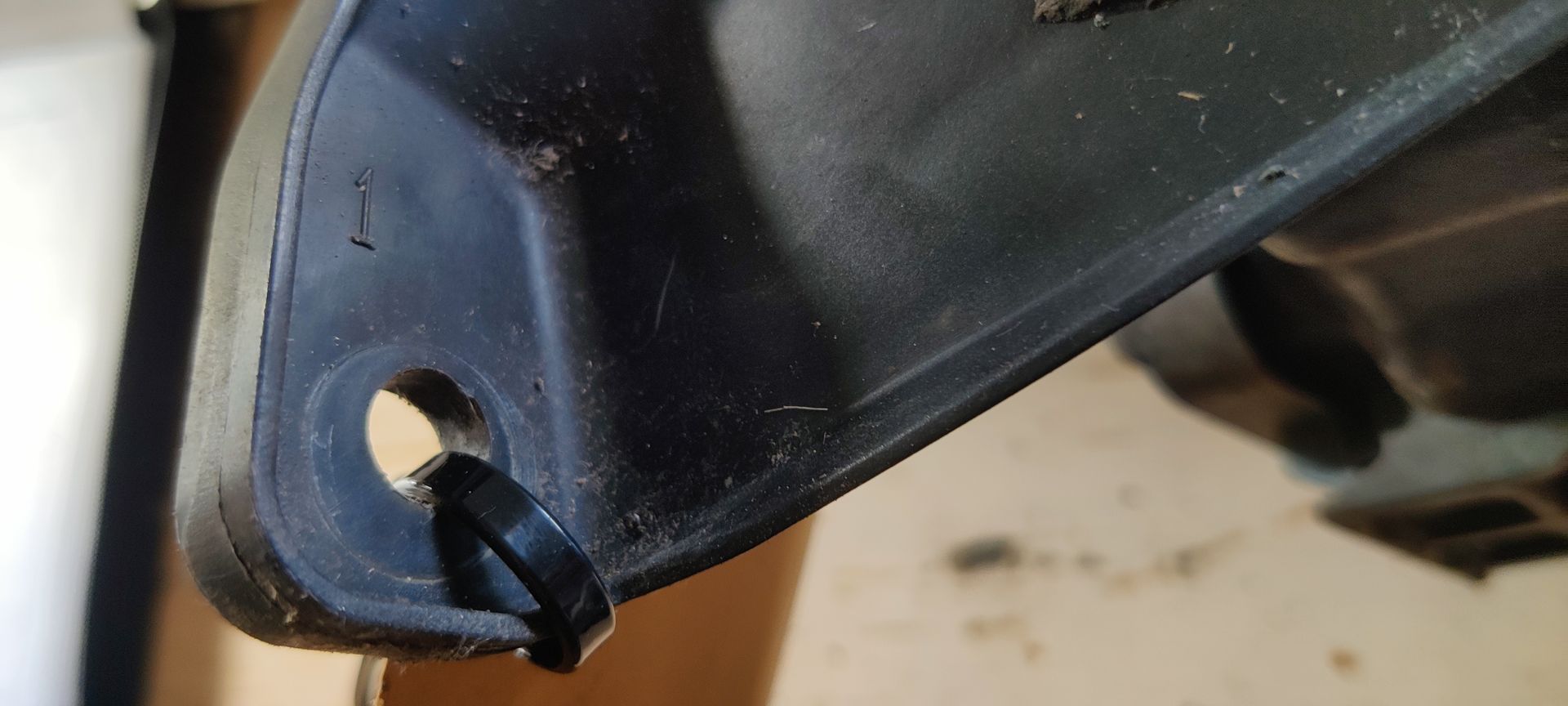 Een enkele autokoplampunit met een heldere lens en een donkere behuizing tegen een witte achtergrond.