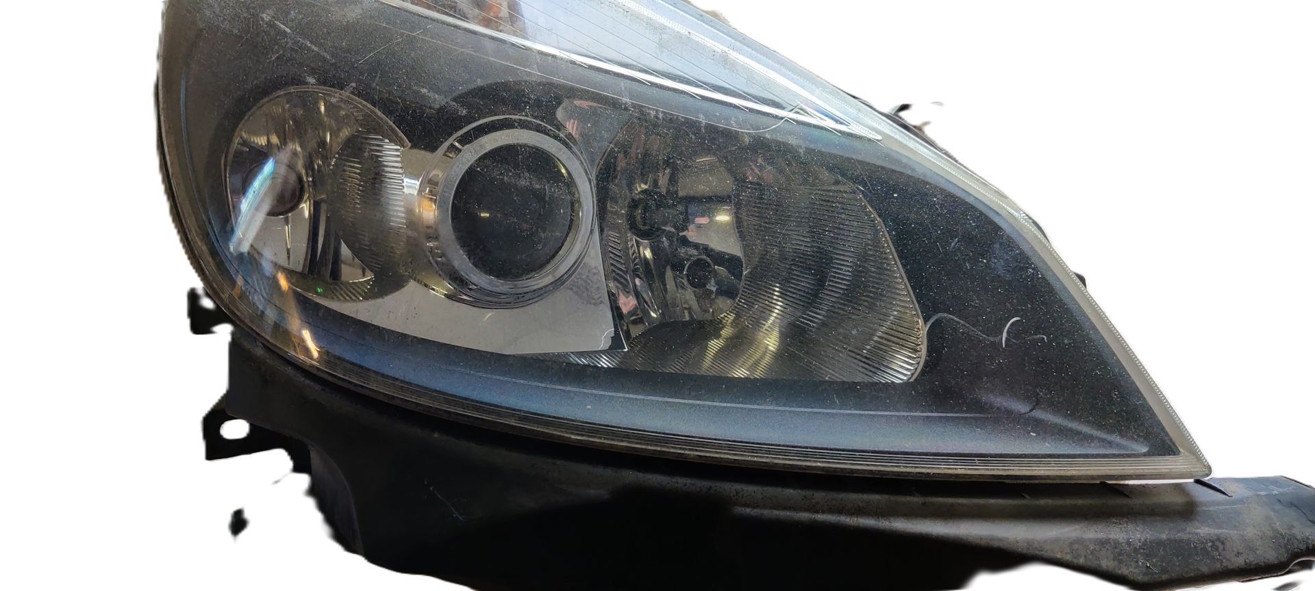 Een zwarte autokoplampunit met projectorlens, geïsoleerd op een witte achtergrond.