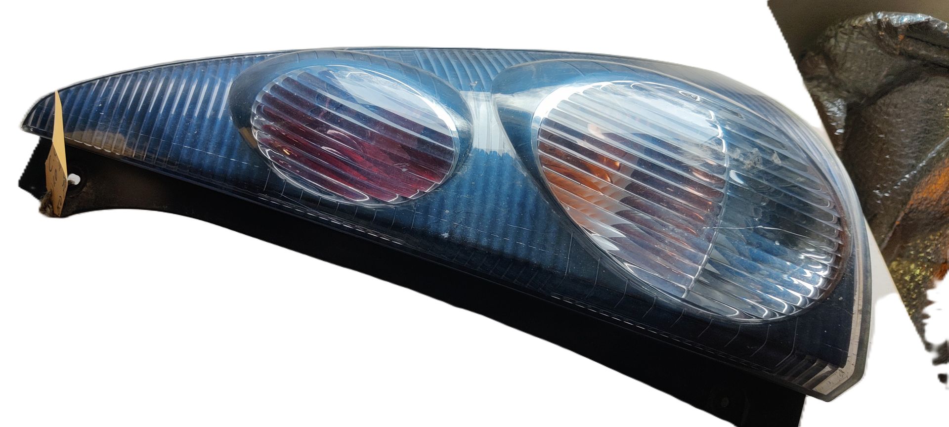 Een blauwe, langwerpige autokoplampunit met twee geïntegreerde, ronde, geribbelde lichtlenzen.