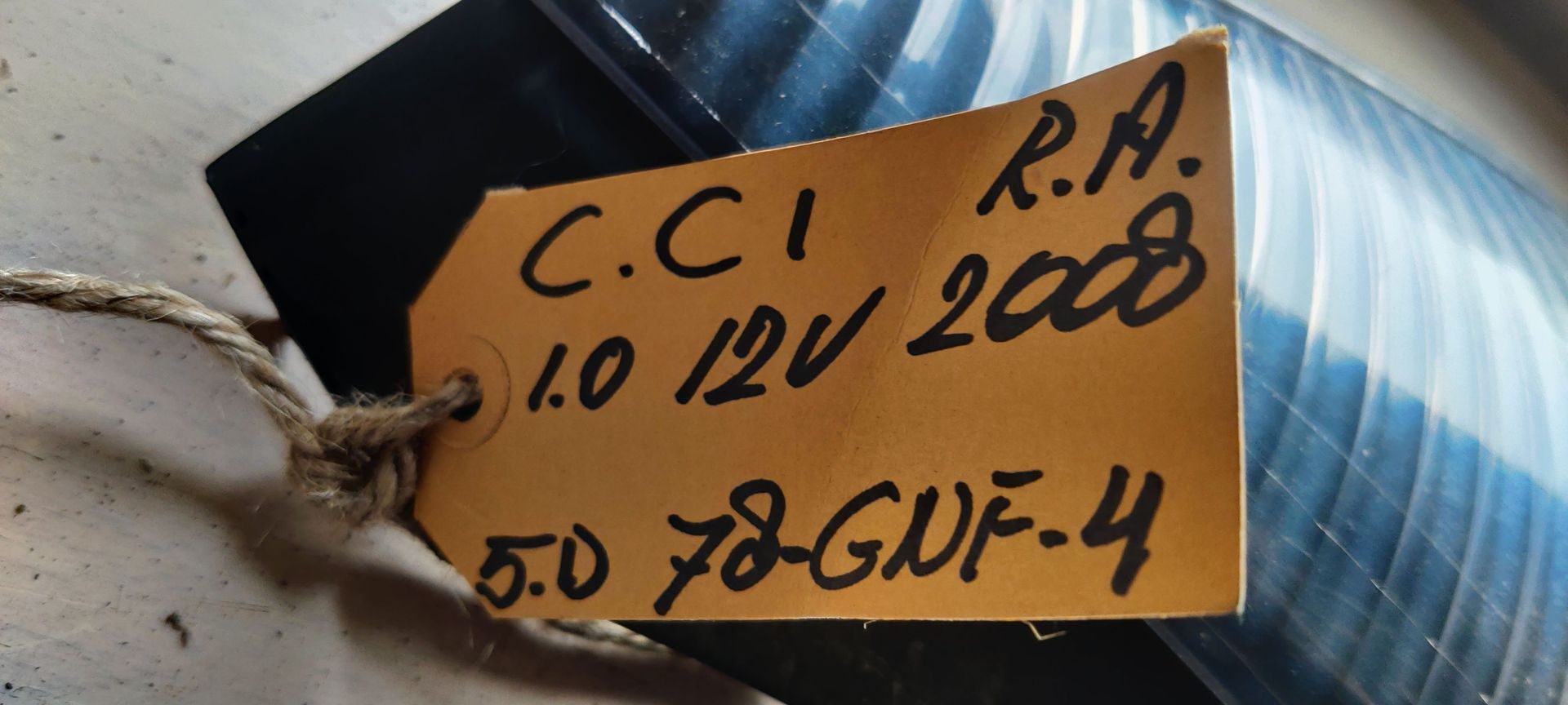 Een blauwe, langwerpige autokoplampunit met twee geïntegreerde, ronde, geribbelde lichtlenzen.