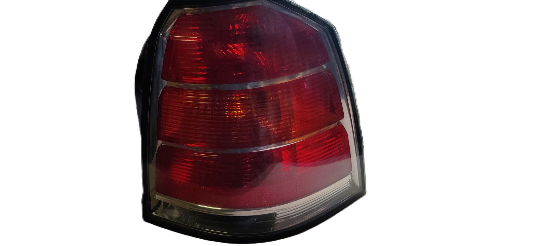 Een rode en transparante achterlichtunit van een auto, geïsoleerd tegen een witte achtergrond.
