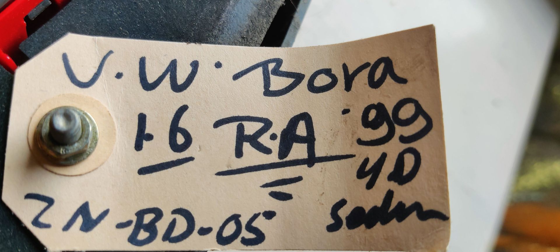 Een rode autoachterlichtunit met een transparant lensgedeelte aan de onderkant, geïsoleerd tegen een witte achtergrond.