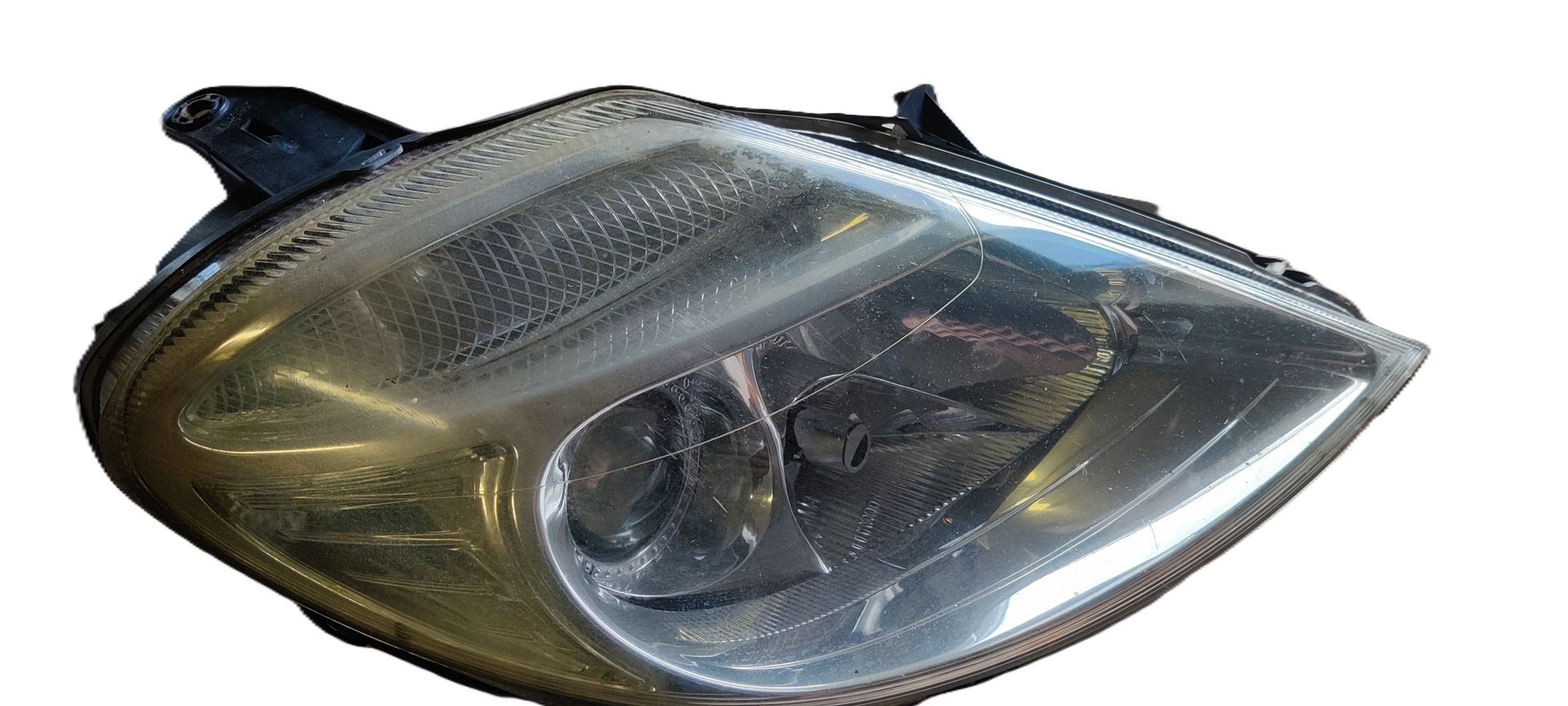 Een transparante plastic koplampunit met een afgeronde, aerodynamische vorm, afgebeeld op een witte achtergrond.