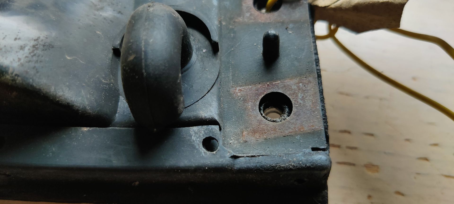 Een zwarte, rechthoekige zijmarkeringslichtunit voor auto's met een lens met textuur, geïsoleerd tegen een witte achtergrond.