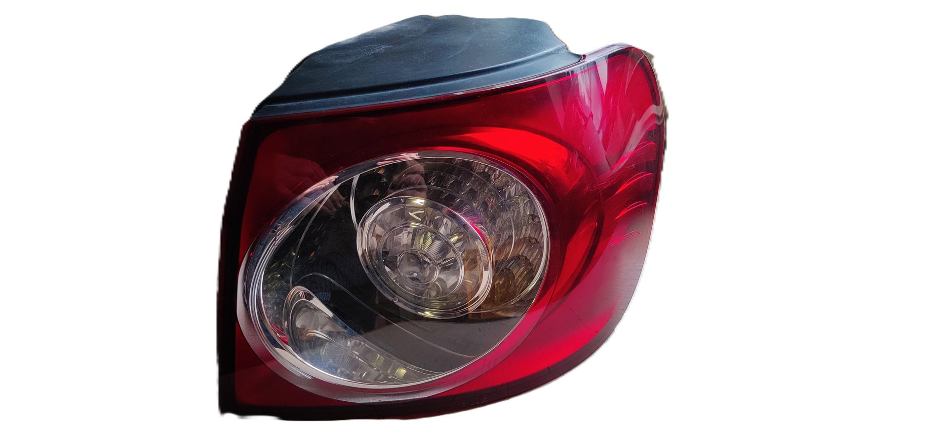 Een rode en transparante plastic achterlichtunit voor auto's, geïsoleerd tegen een witte achtergrond.