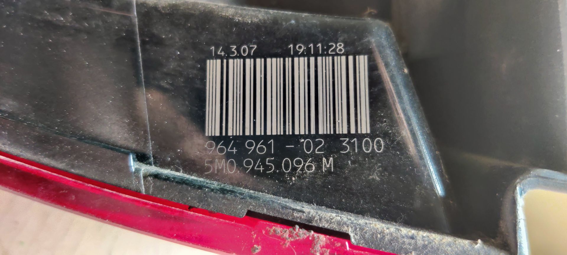 Een rode en transparante plastic achterlichtunit voor auto's, geïsoleerd tegen een witte achtergrond.
