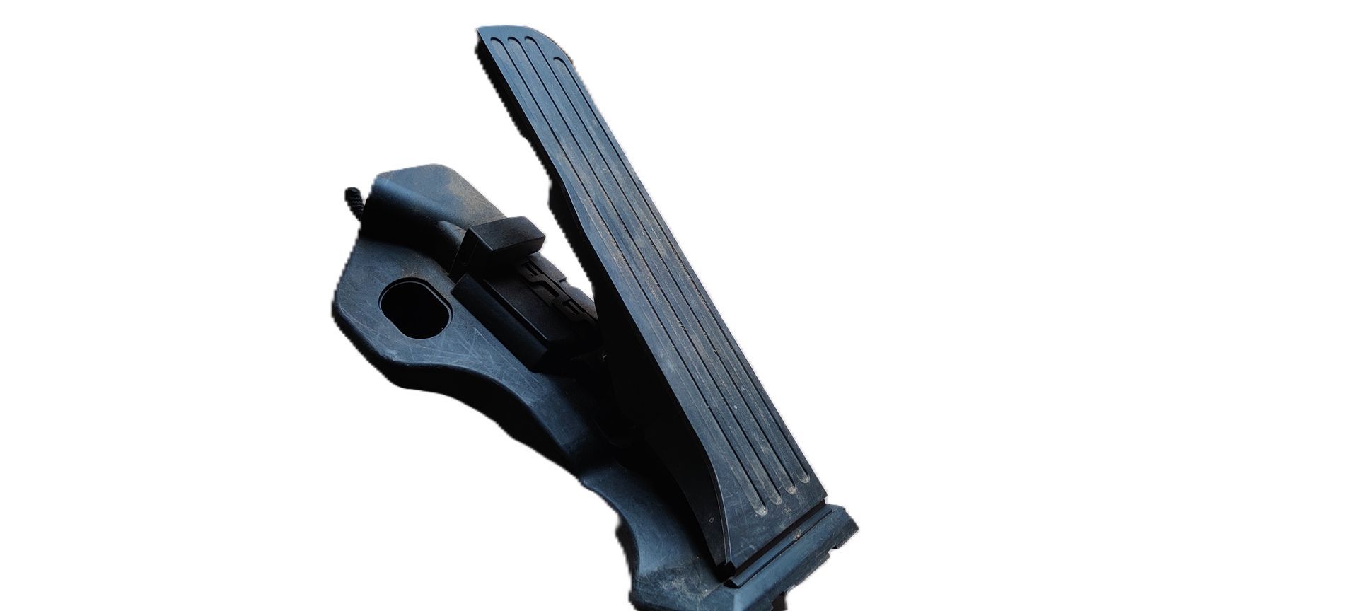 Een zwart, gestructureerd gaspedaal van een auto, schuin omhoog gericht tegen een witte achtergrond.