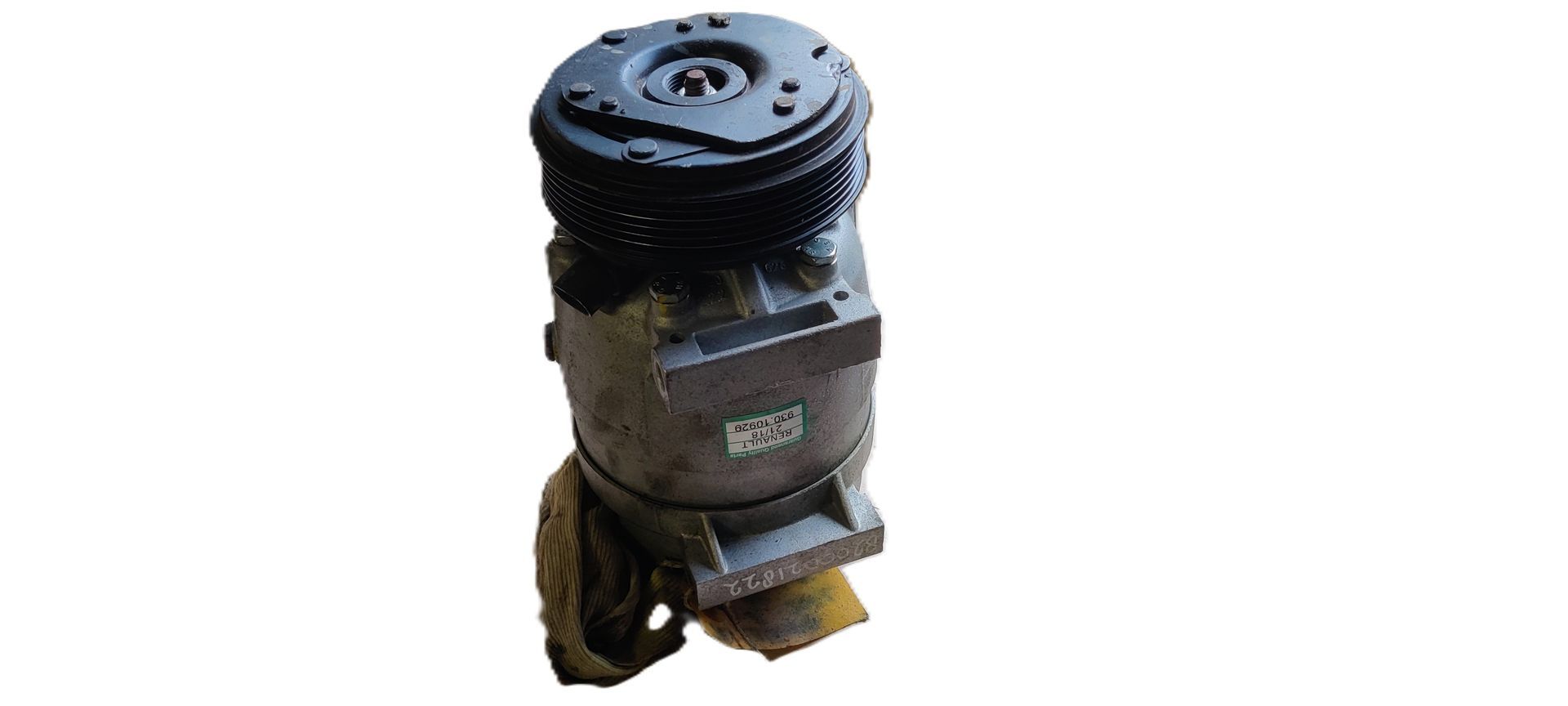 Een grijze airco-compressor voor auto's met een zwarte poelie, verticaal staand op een witte achtergrond.