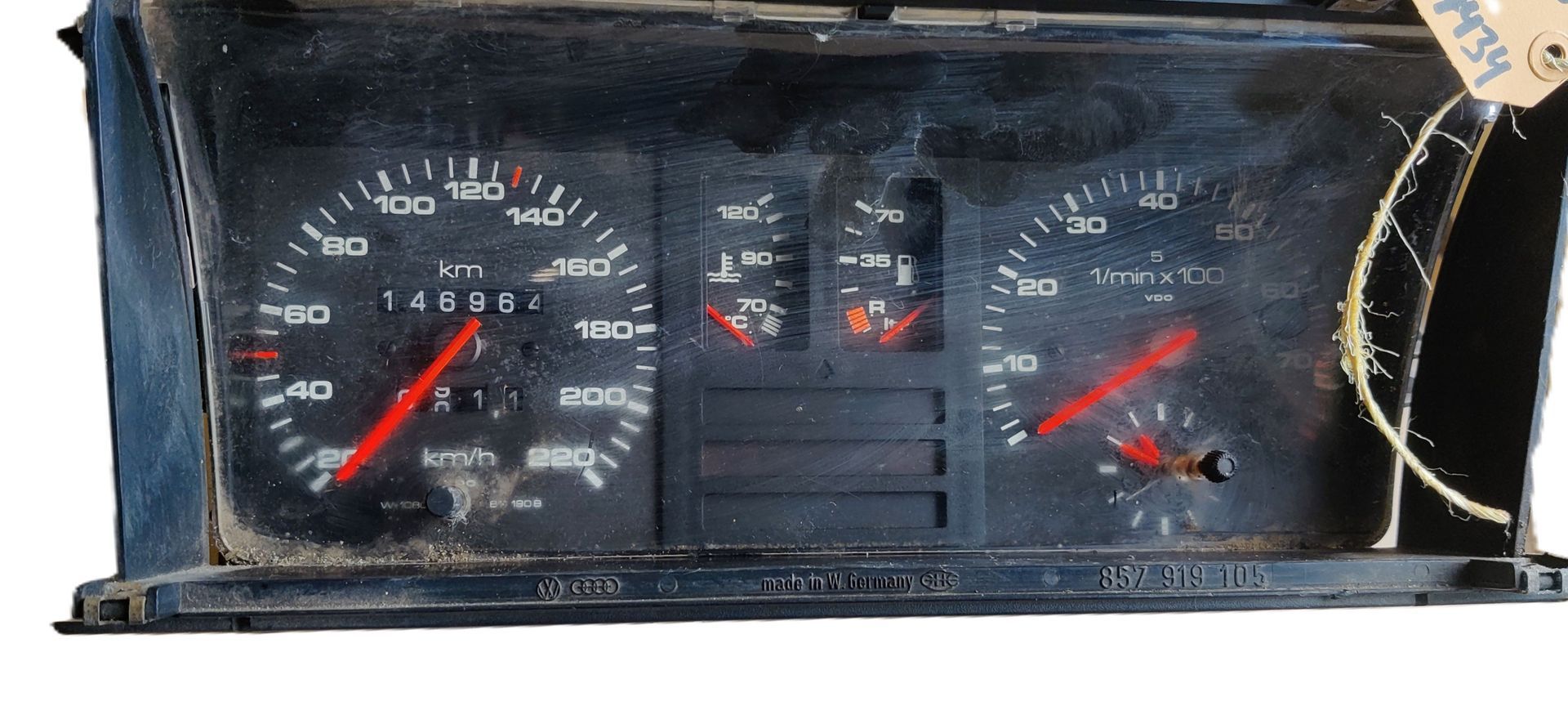 Een vintage zwart dashboard met een snelheidsmeter, toerenteller en brandstof-/temperatuurmeter, beide aangegeven in km/u.