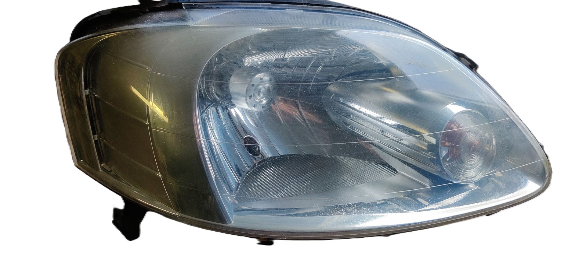 Een enkele zilverkleurige en zwarte autokoplampunit, van voren gezien tegen een witte achtergrond.