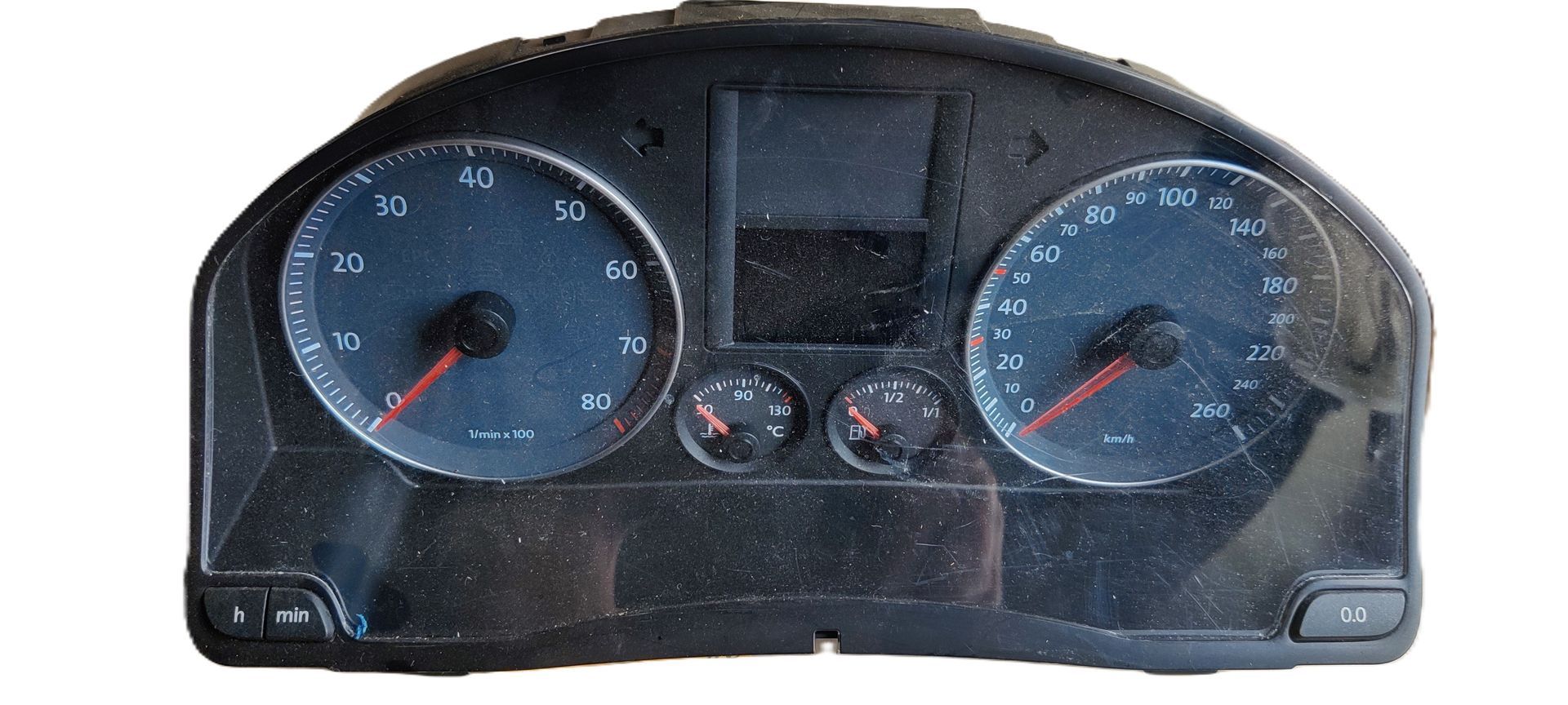 Een stoffig Volkswagen-dashboard met analoge snelheidsmeter, toerenteller, brandstofmeter en temperatuurmeter.