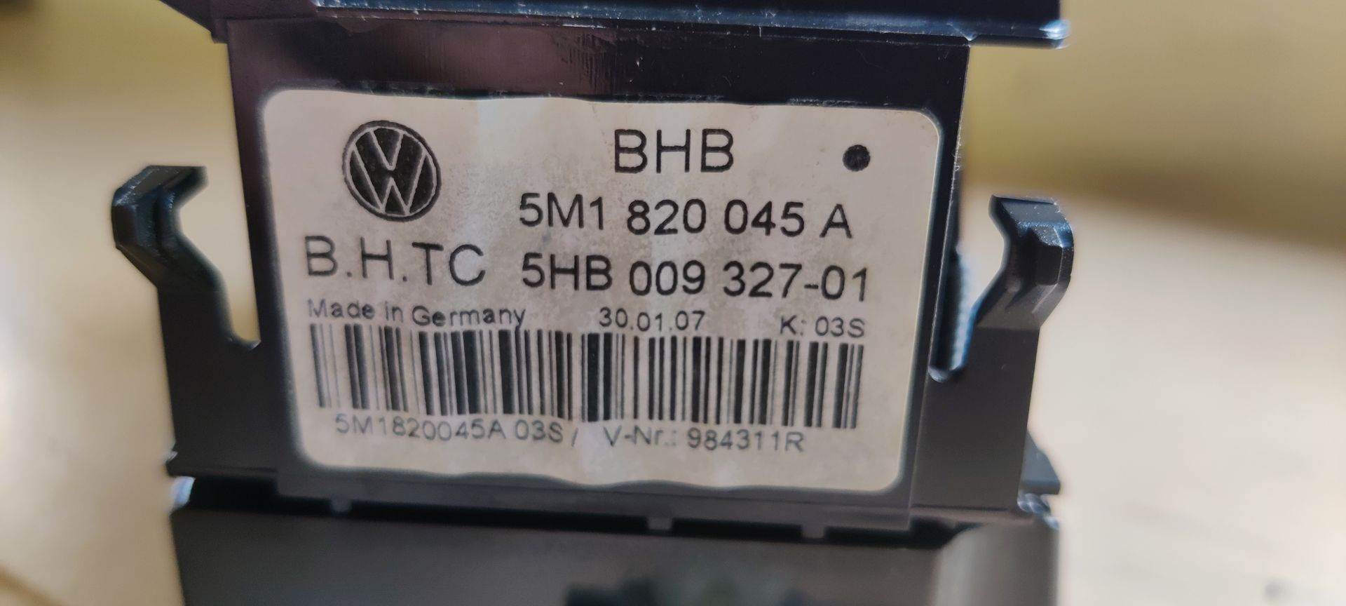 Een zwarte bedieningseenheid voor autoverwarming en -airconditioning met drie ronde instelknoppen en centrale drukknoppen.