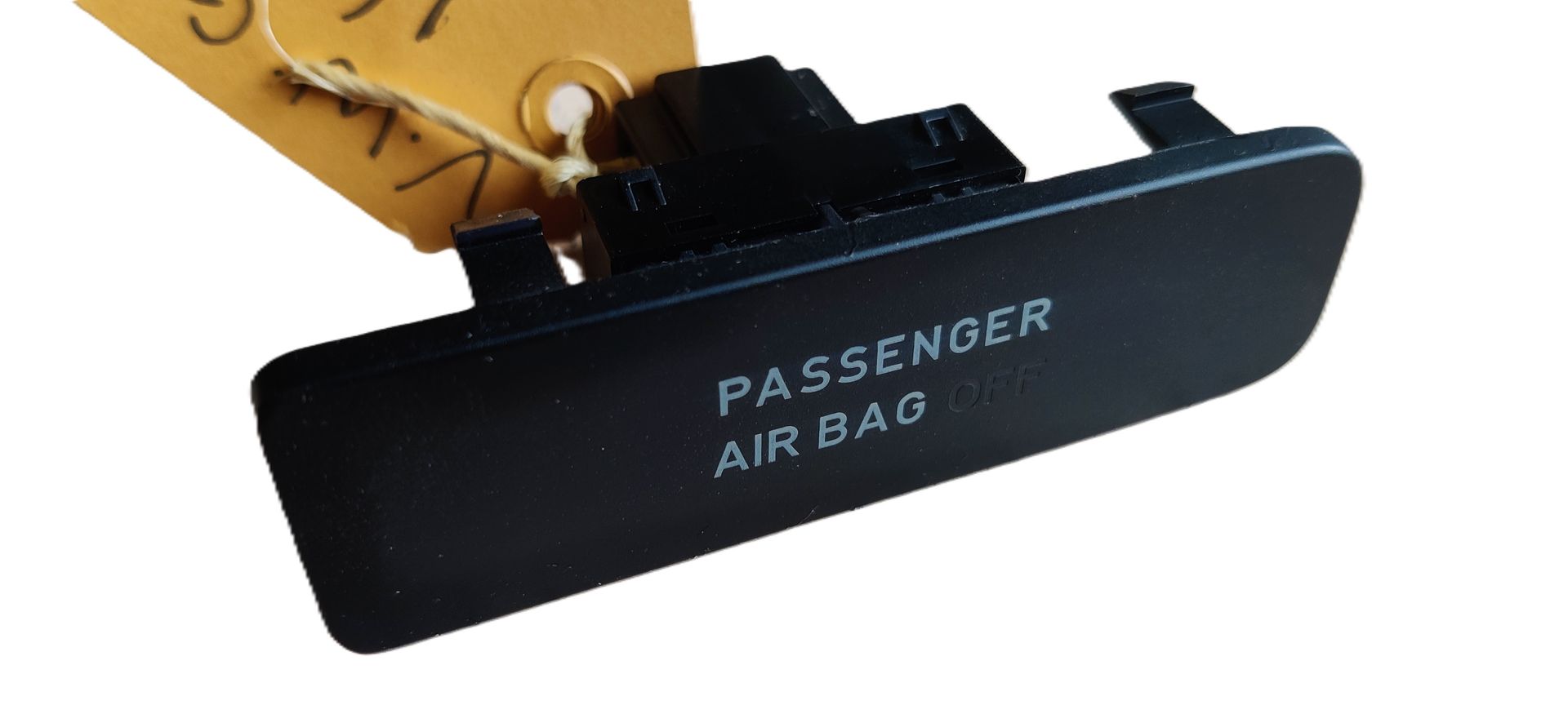 Een zwart afdekplaatje voor het waarschuwingslampje van de passagiersairbag met daarop gedrukte tekst.