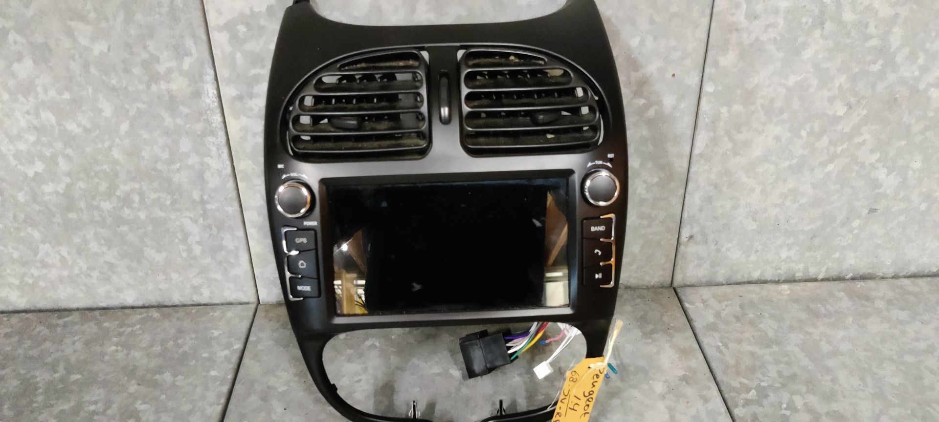 Een zwart autodashboard met middenconsole, twee ventilatieopeningen, een geïntegreerd scherm en bedieningsknoppen.