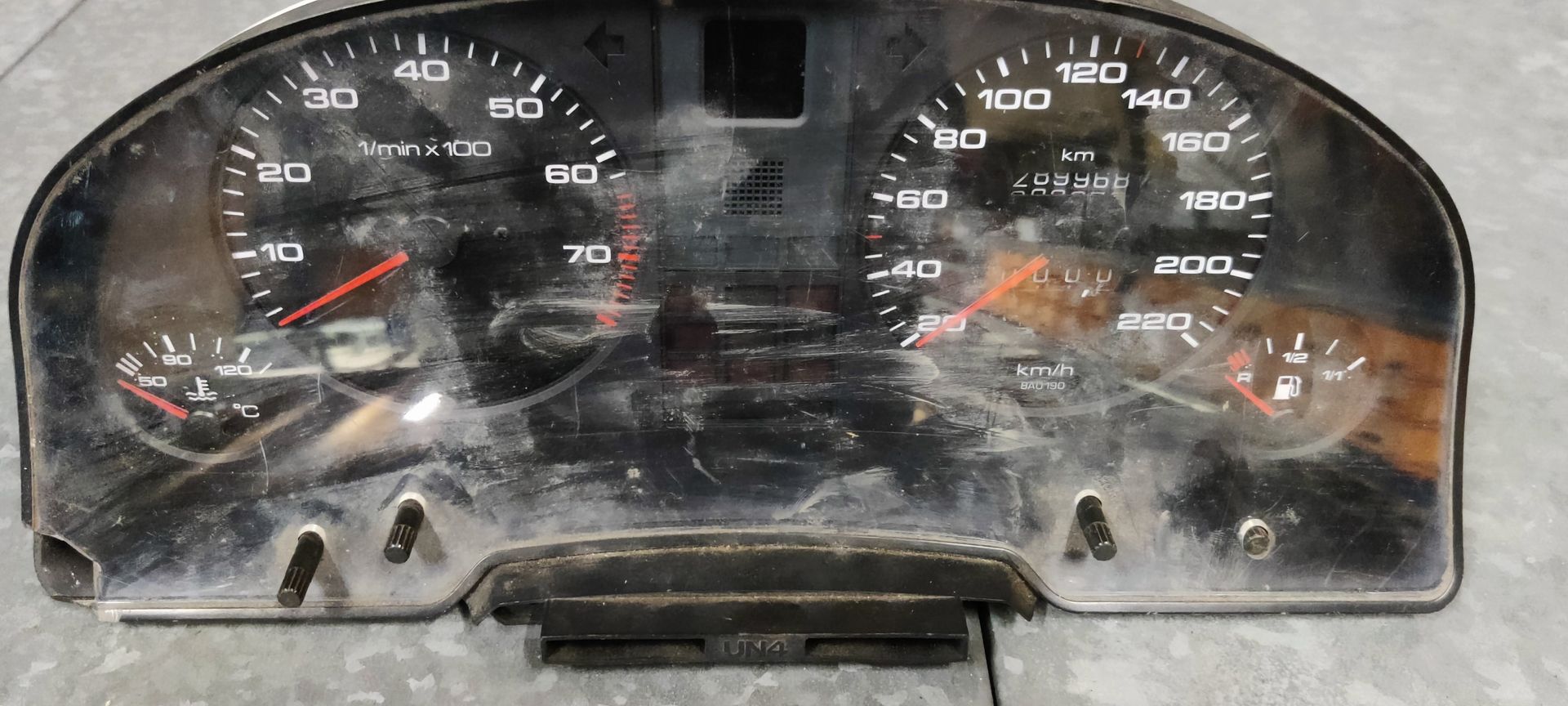 Een instrumentenpaneel voor auto's met een analoge toerenteller, snelheidsmeter, brandstofmeter en temperatuurmeter.