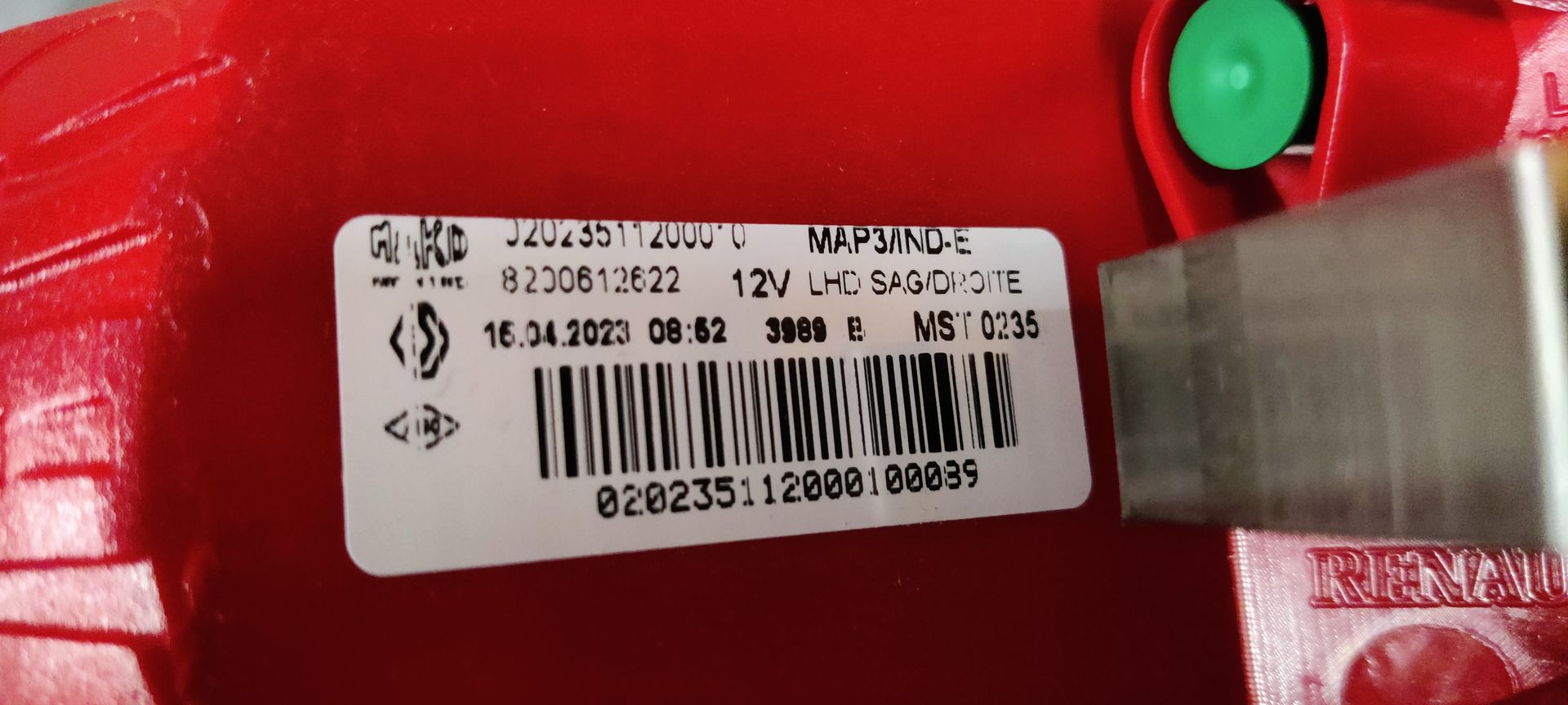 Een nieuw rood Renault-achterlicht in een beschermende plastic zak, dat voor de originele merkverpakking staat.