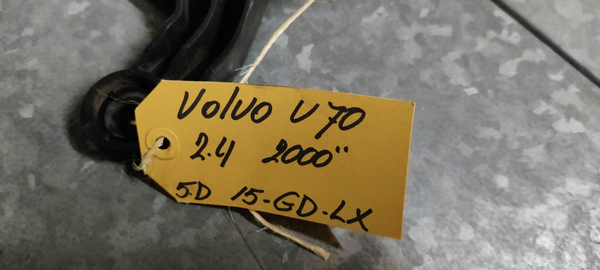 Zwarte koelventilator voor autoradiatoren met een aangehechte elektronische regelmodule op een grijze ondergrond.