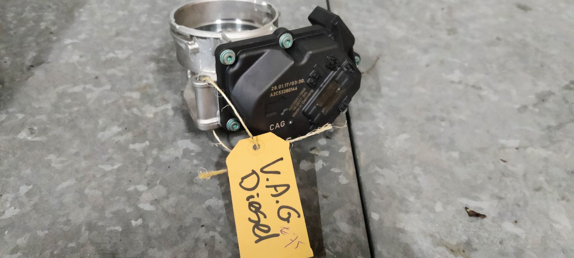 Een VAG-dieselgasklephuis met een cilindrische metalen inlaat en een zwarte kunststof behuizing voor de elektronica.