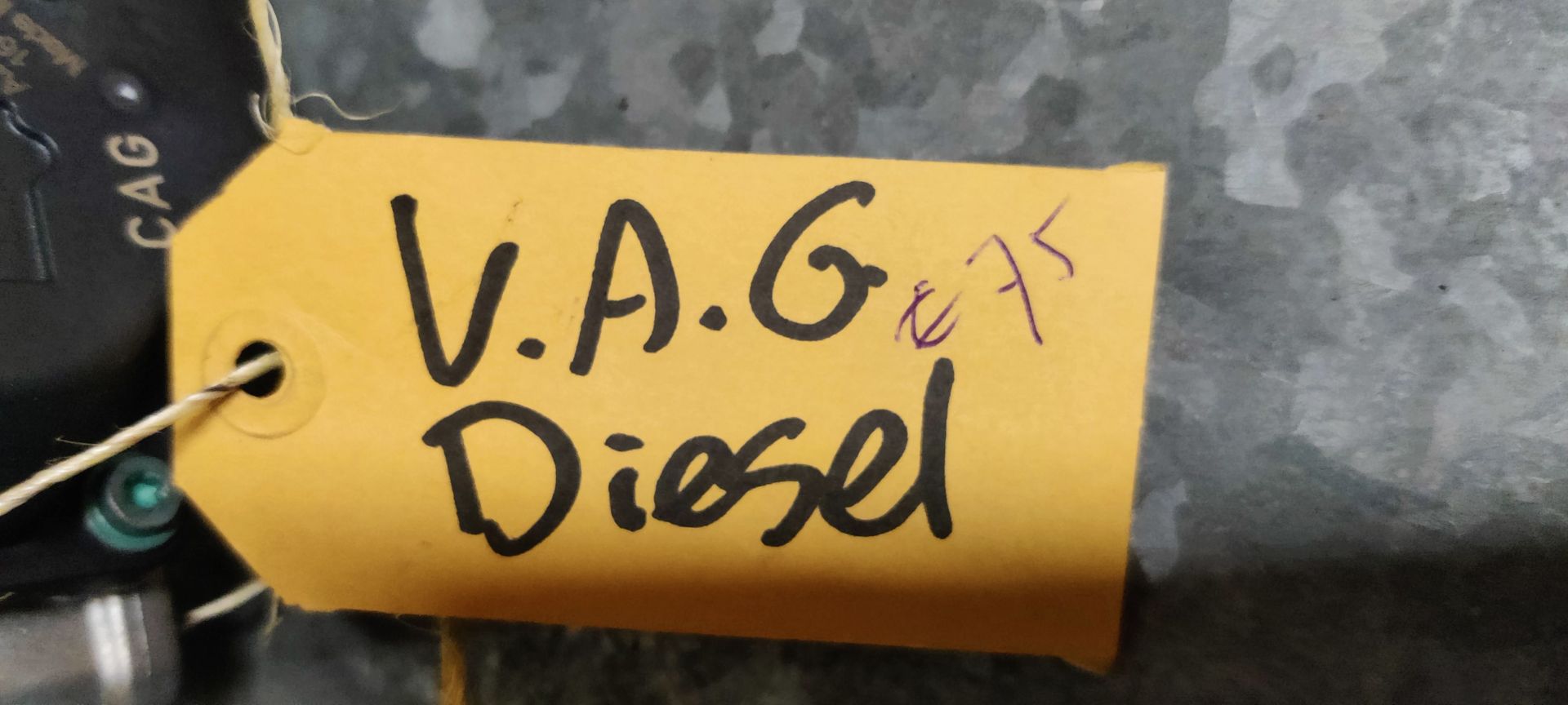 Een VAG-dieselgasklephuis met een cilindrische metalen inlaat en een zwarte kunststof behuizing voor de elektronica.
