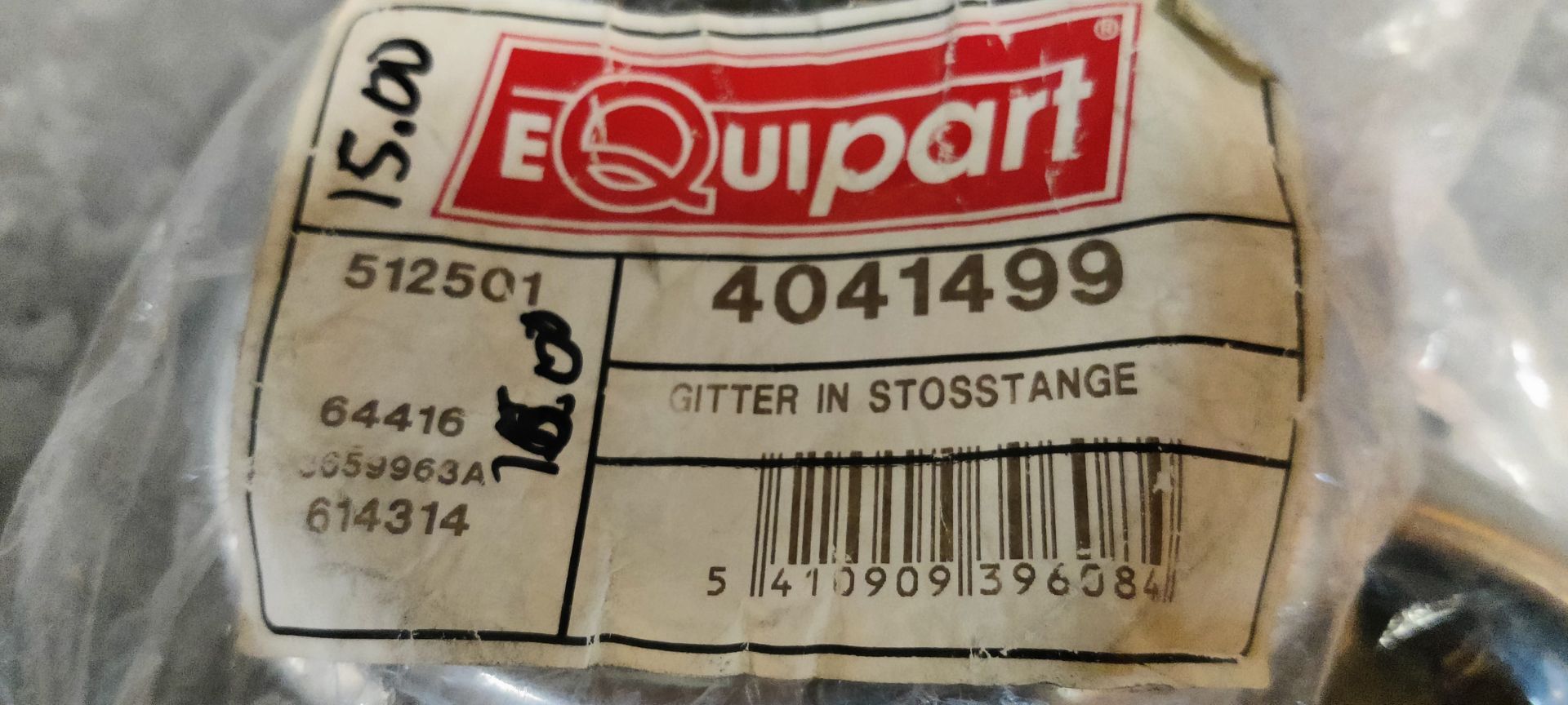 Twee chromen metalen wieldopringen in doorzichtige plastic zakjes, rustend op een grijs, gestructureerd metalen oppervlak.