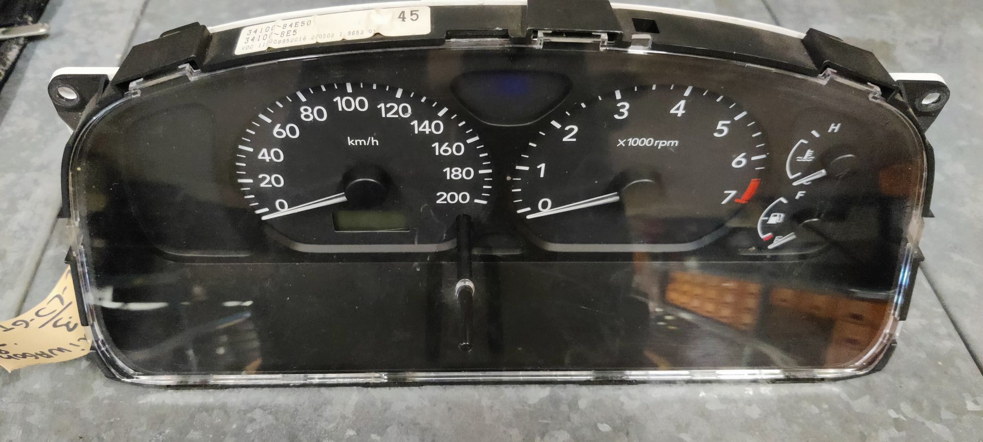 Een zwart instrumentenpaneel voor auto's met een snelheidsmeter, toerenteller, brandstofmeter en temperatuurmeter.