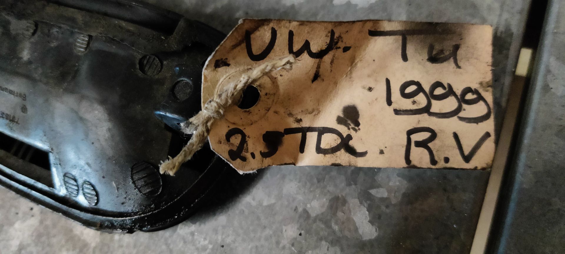 Een zwarte buitendeurhendel voor auto's met geïntegreerd sleutelcilinder, gezien vanaf de voorkant.