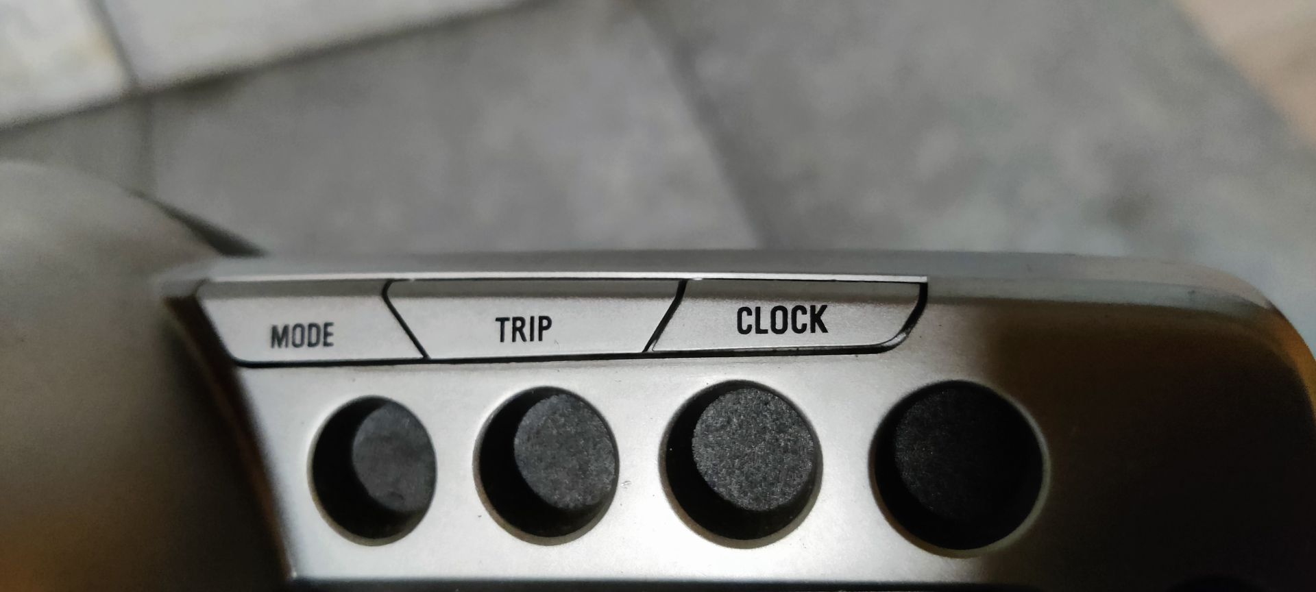 Een grijs, afgerond instrumentenpaneel voor autosnelheidsmeters met één wijzerplaat en een aangrenzend digitaal display.