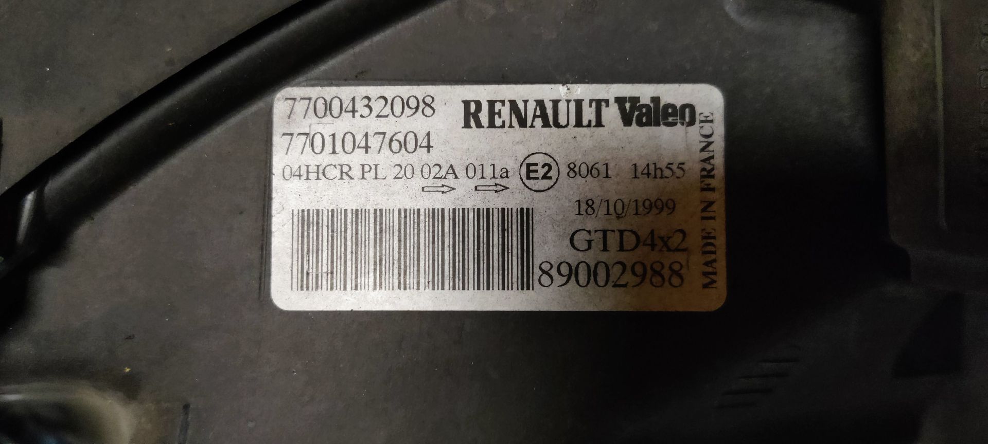 Een enkele autokoplampunit met een heldere lens, verchroomde interne reflectoren en een oranje zijmarkeringslicht.