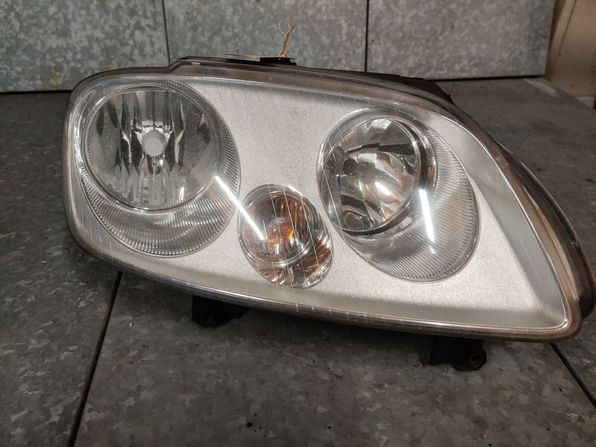 VW Caddy de rechter koplamp van een uit 2008, gebruikt. Deze ligt bij Eddie Stegeman in Exel.