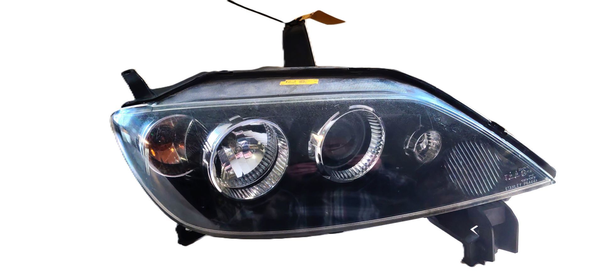 Een stijlvolle, zwarte koplampunit voor de aftermarket, met geïntegreerde projectorlenzen en reflectorlampen.