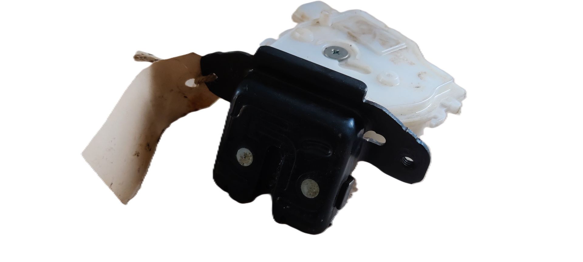 Een zwart metalen kofferbakvergrendelingsmechanisme, bevestigd aan een witte plastic behuizing.