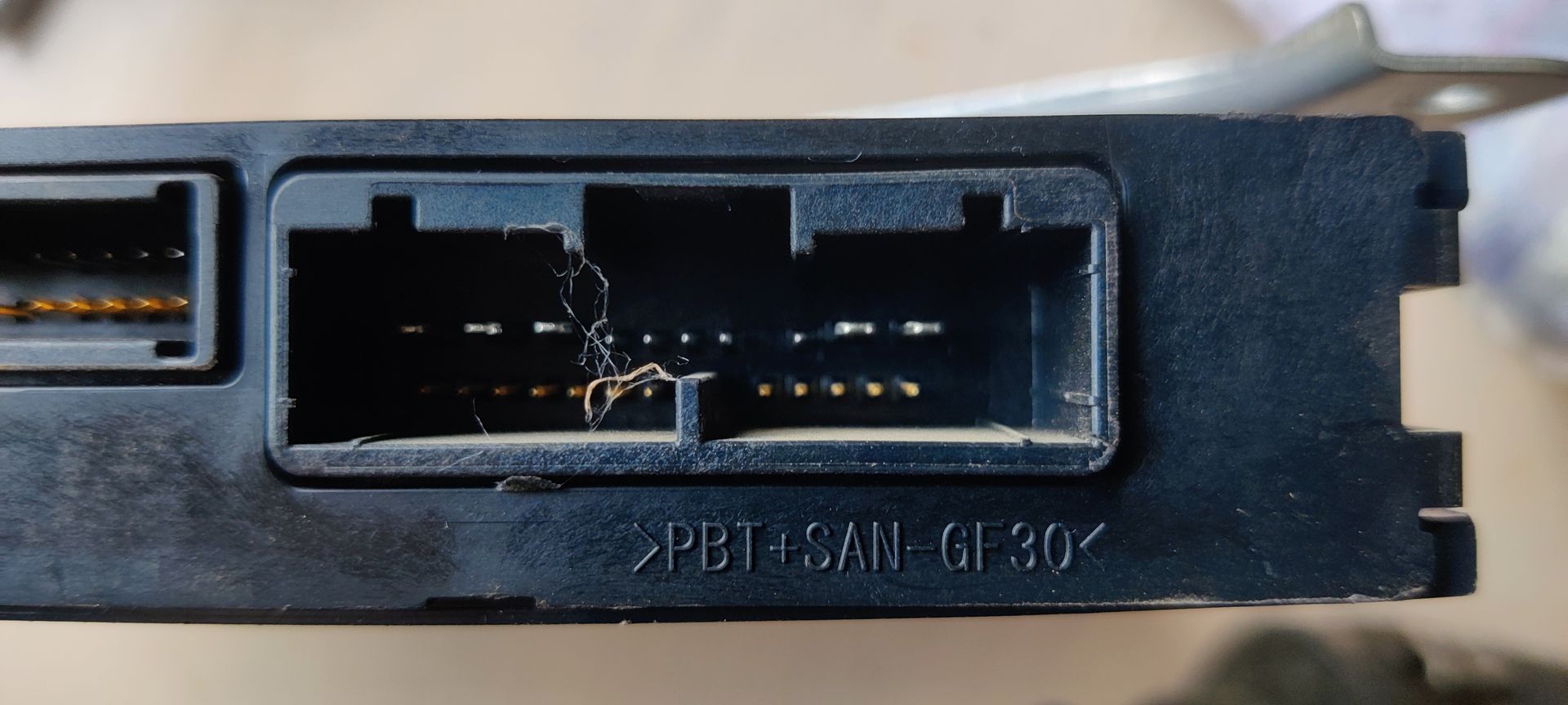 Een motorregelunit van een Toyota Yaris met een metalen montagebeugel en een handgeschreven identificatielabel.