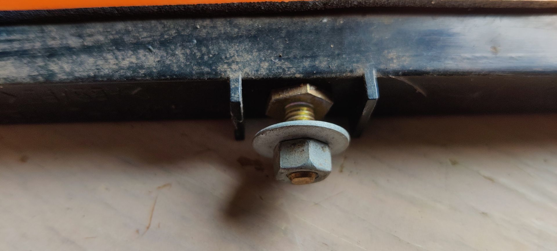 Een donkerblauwe metalen autodeurhendel met sleutelgat, van de zijkant gezien tegen een witte achtergrond.