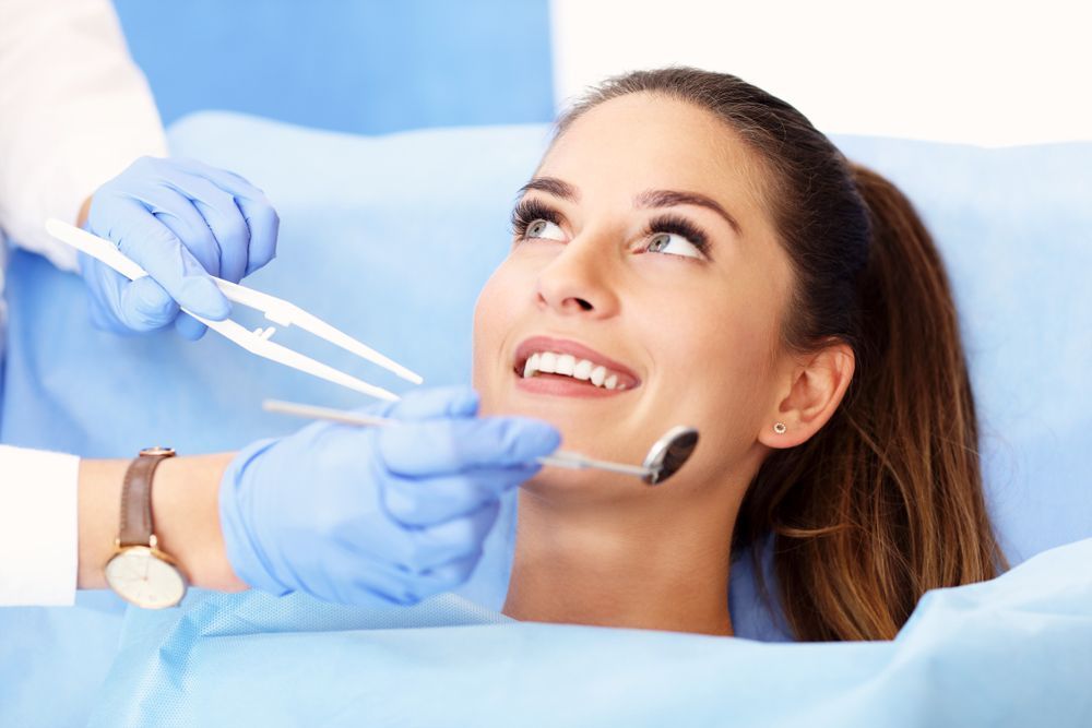 Woman Laying In A Dental Chair Getting Her Teeth Examined By A Dentist — Aspire Dental in Townsville, QLD