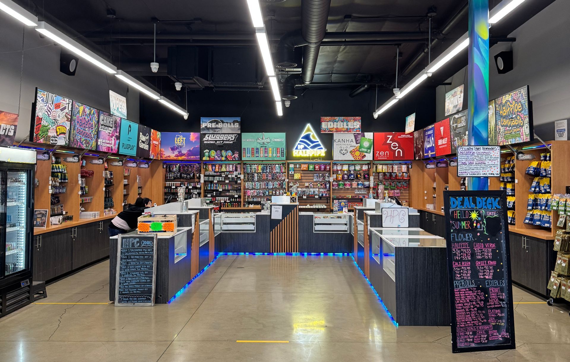 Indoor arcade with rows of prize games, colorful neon signs, and empty checkout counters