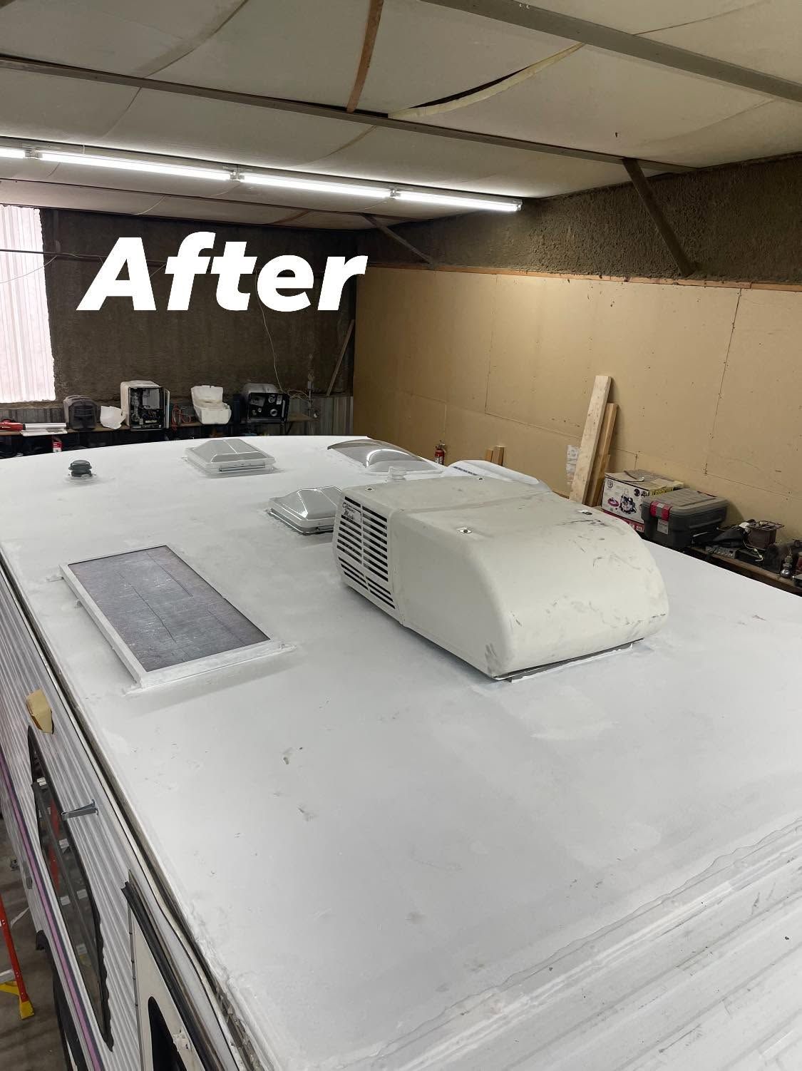 After view of a white RV roof with vents in an indoor workshop