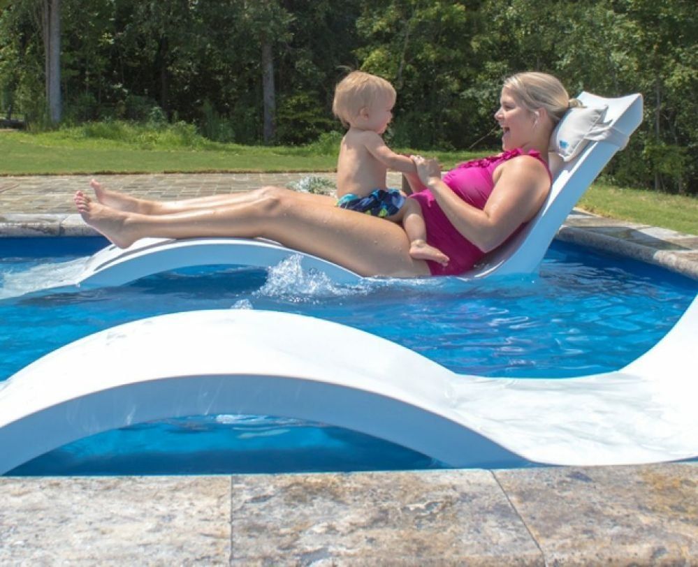 Woman and baby lounging on a white float in a blue swimming pool.