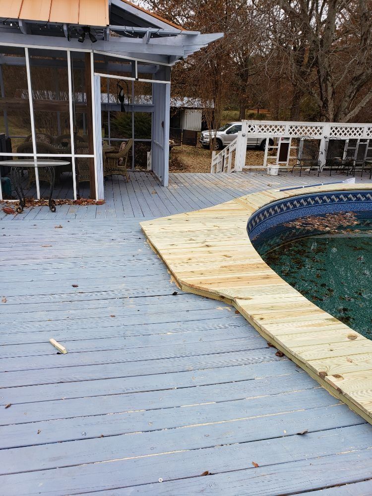 Backyard pool deck with a partially repaired wooden boardwalk and screened patio.