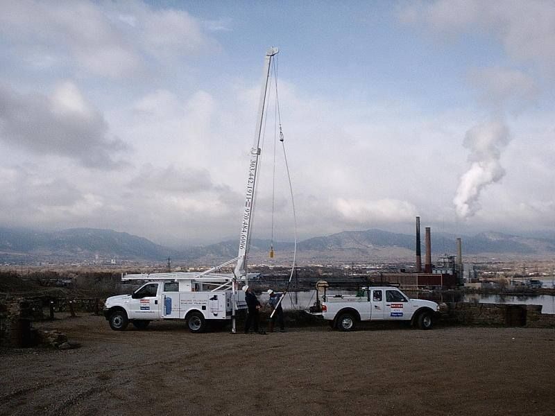 Two white trucks are parked next to each other in a dirt field Two white trucks are parked next to each other in a dirt field