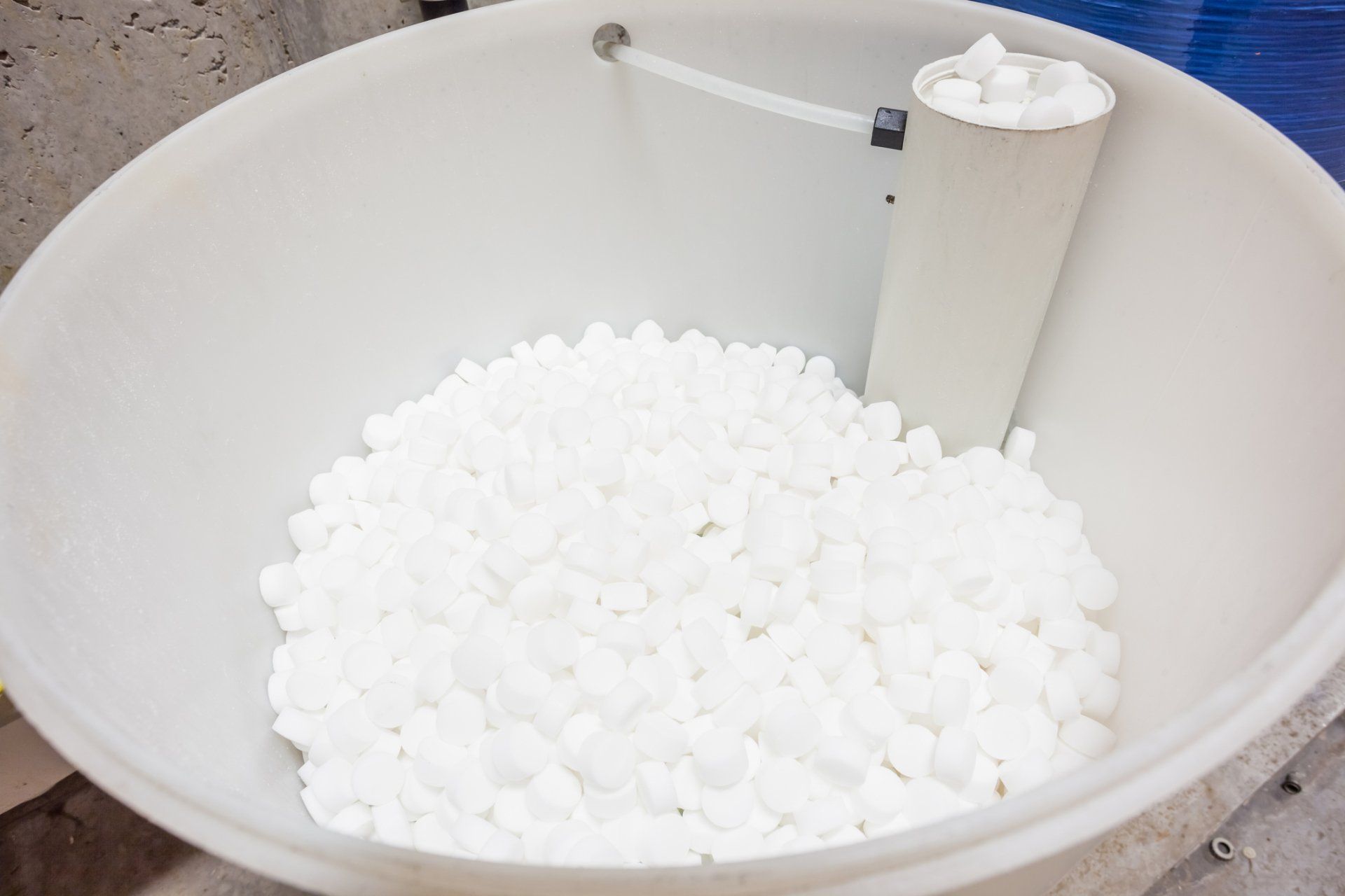A white bowl filled with white balls next to a pipe. A white bowl filled with white balls next to a pipe.