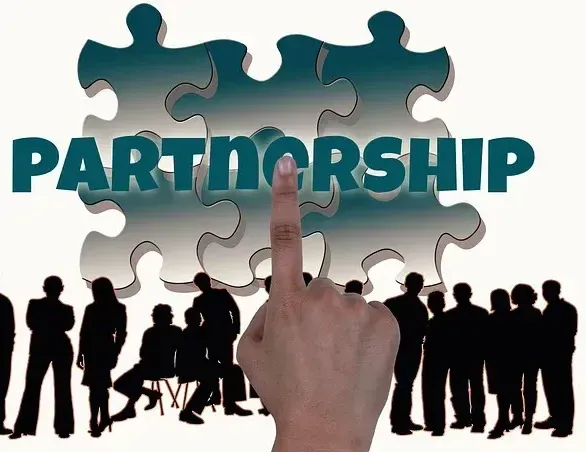 A hand is pointing at a puzzle piece that says partnership