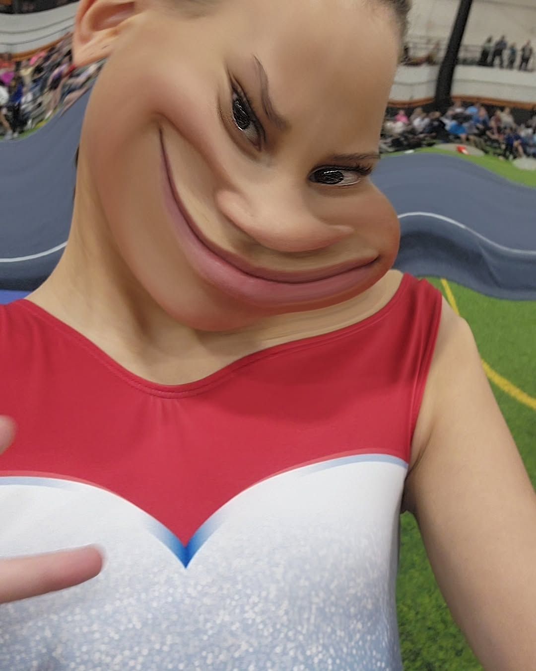 Person in a red-and-white top with a distorted face, standing on a sports court.