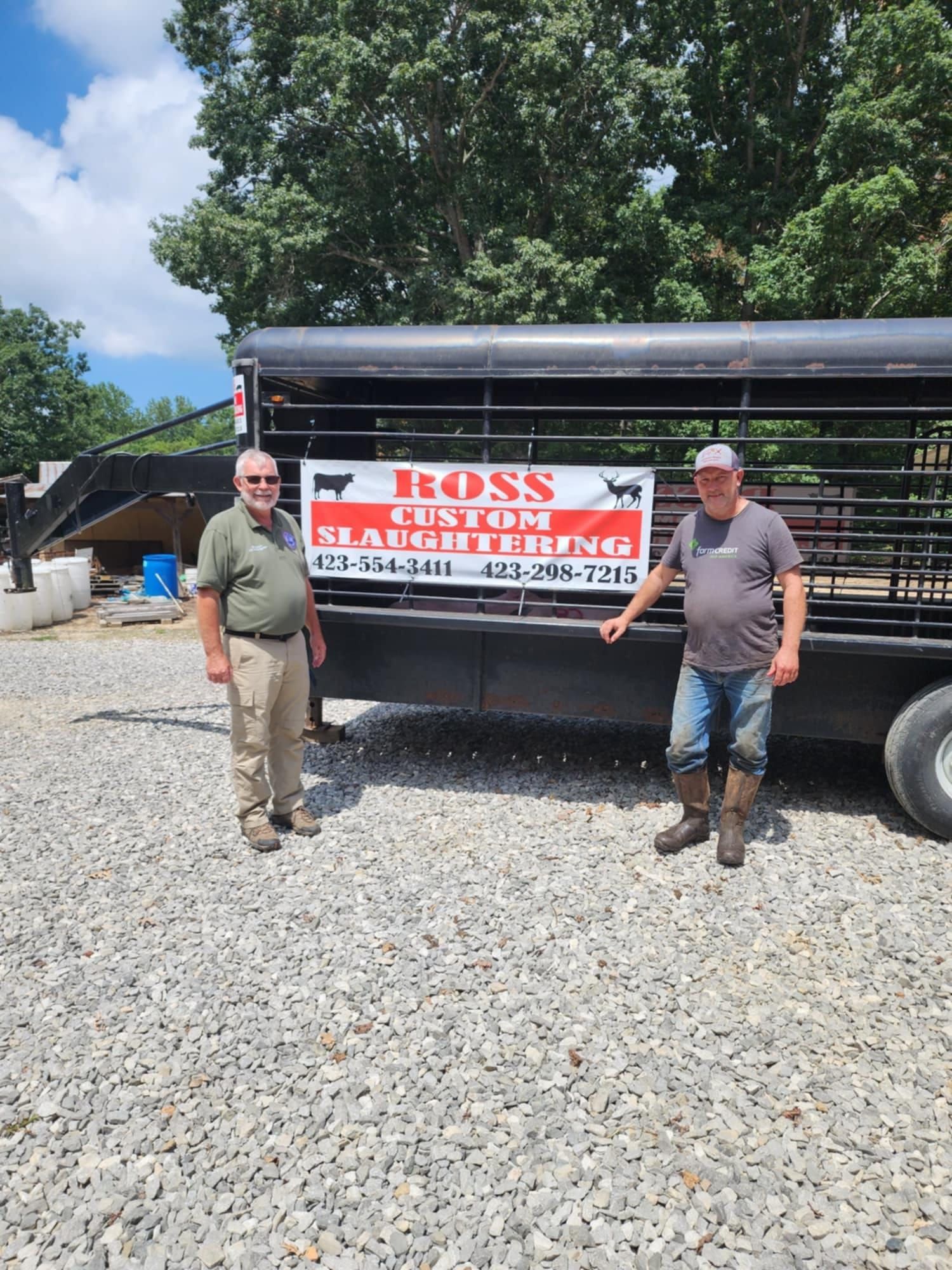 Two men stand by a trailer with a