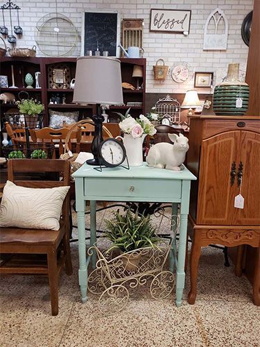 A room filled with furniture and a table with a clock on it.