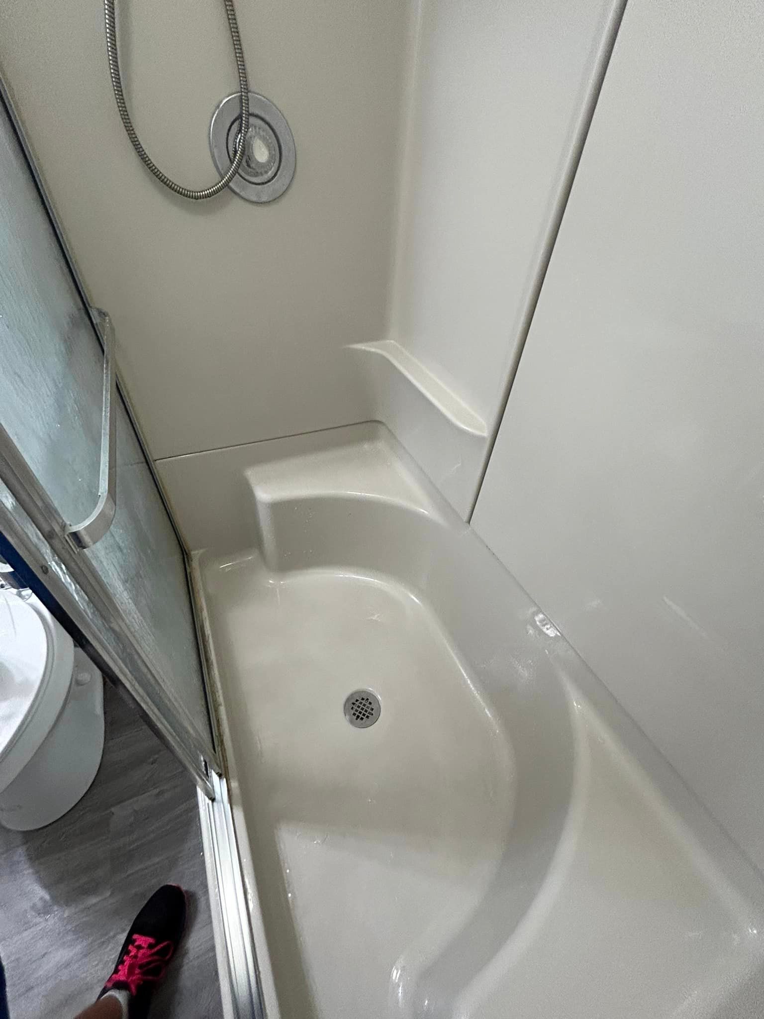 A bathroom with a shower and a toilet.