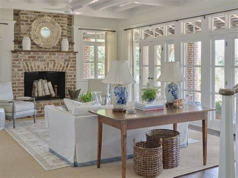 A living room with a fireplace , couch , table and chairs. A living room with a fireplace , couch , table and chairs.
