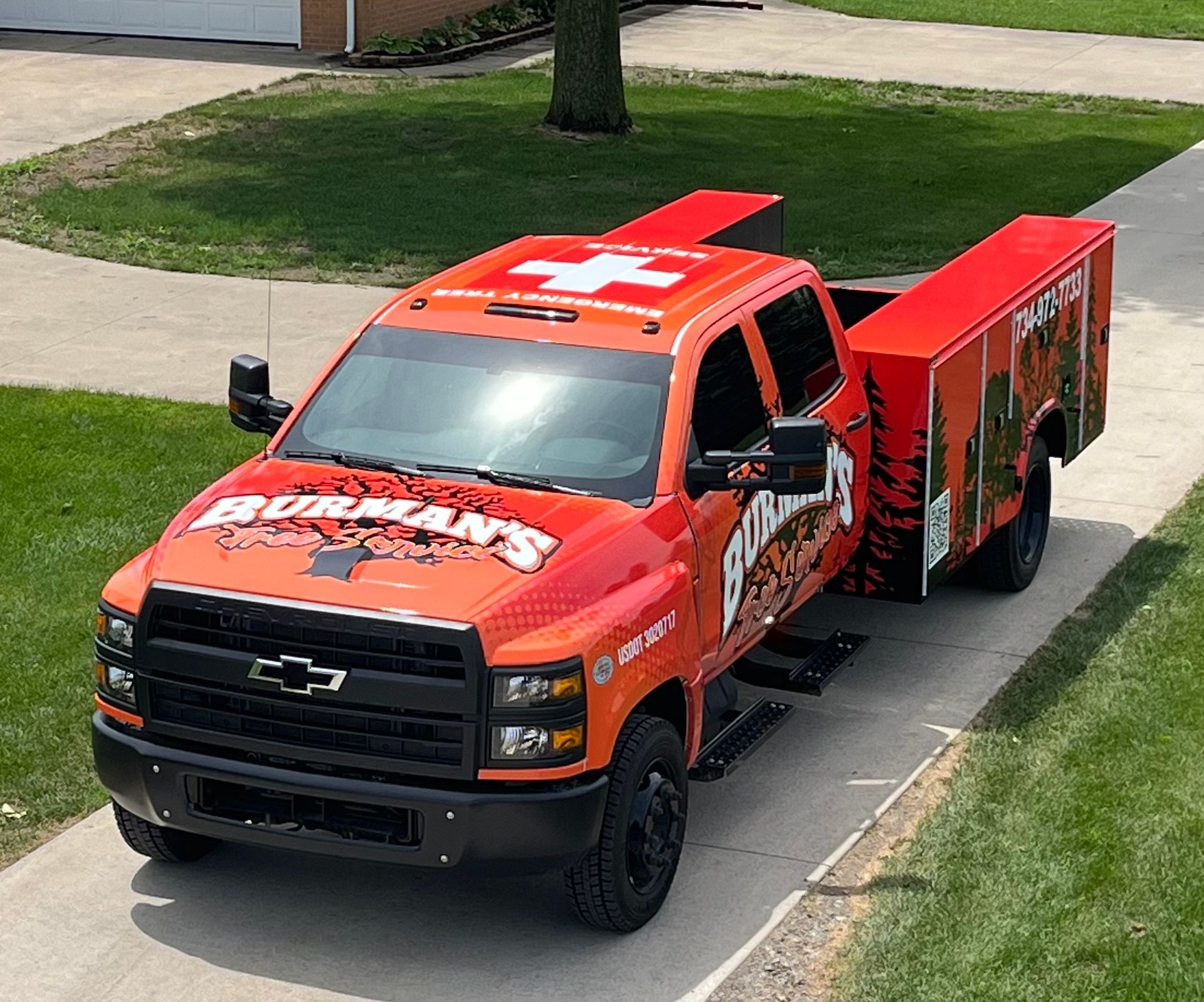 Red emergency response truck parked on a driveway, with a large red trailer attached.